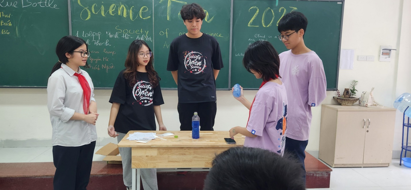 A group of people standing around a tableDescription automatically generated