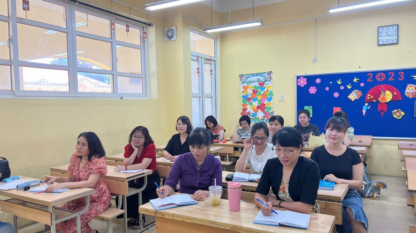 A group of people sitting at desks in a classroomDescription automatically generated