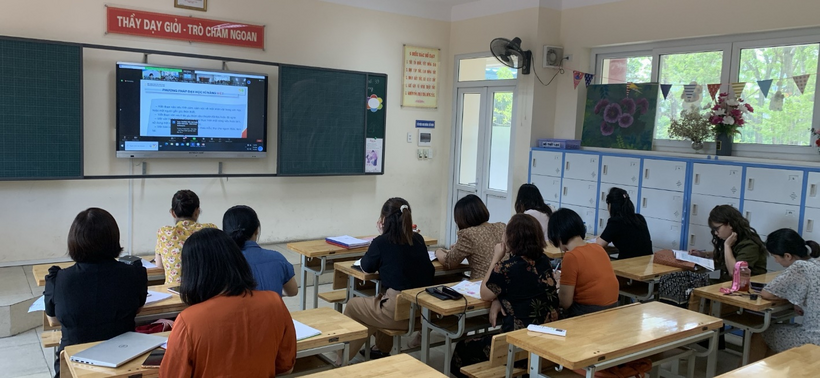 A group of people sitting at desks in a classroomDescription automatically generated