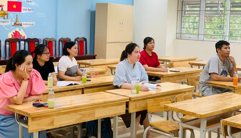 A group of people sitting at desks in a classroomDescription automatically generated