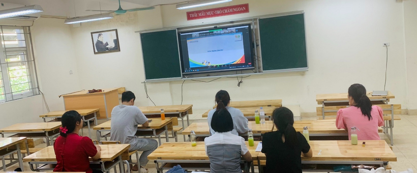 A group of people sitting at desks in a classroomDescription automatically generated