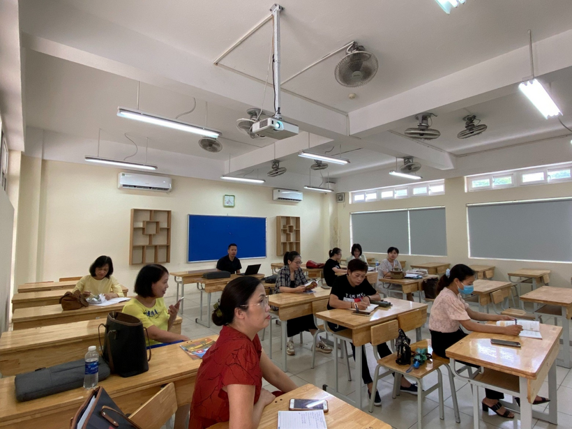 A group of people sitting at desks in a classroomDescription automatically generated