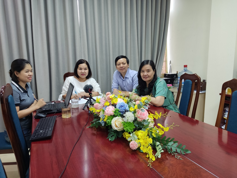A group of people sitting around a table with flowers

Description automatically generated