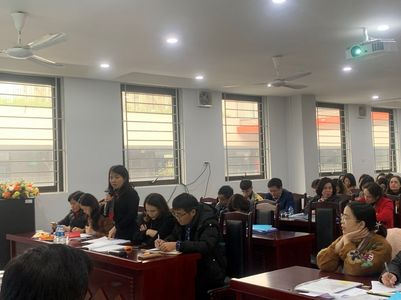 A group of people sitting at desks in a room

Description automatically generated