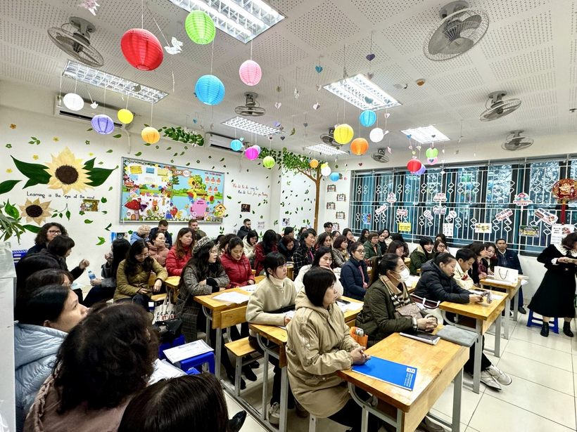 A group of people sitting at desks in a classroomDescription automatically generated