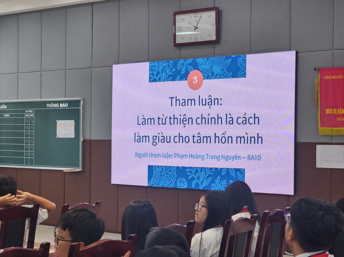 A person standing in front of a screenDescription automatically generated