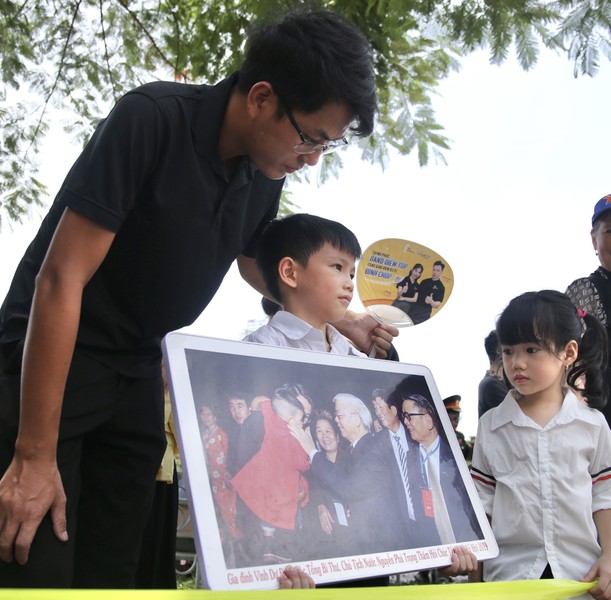 A person holding a picture of a child

Description automatically generated