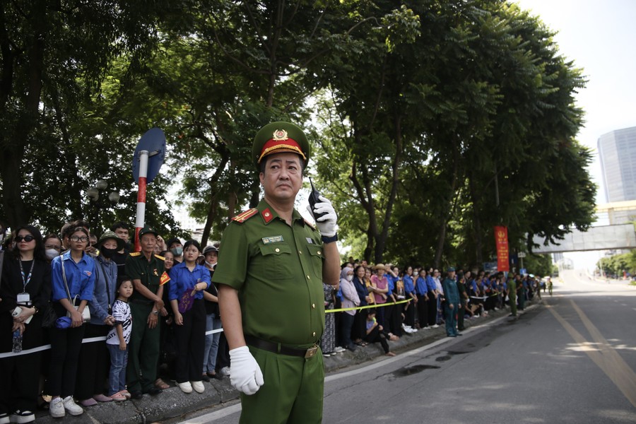 A person in uniform standing on the street

Description automatically generated