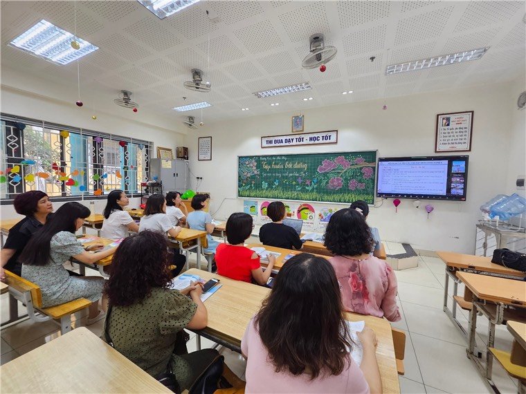 A group of people sitting at desks in a classroom

Description automatically generated