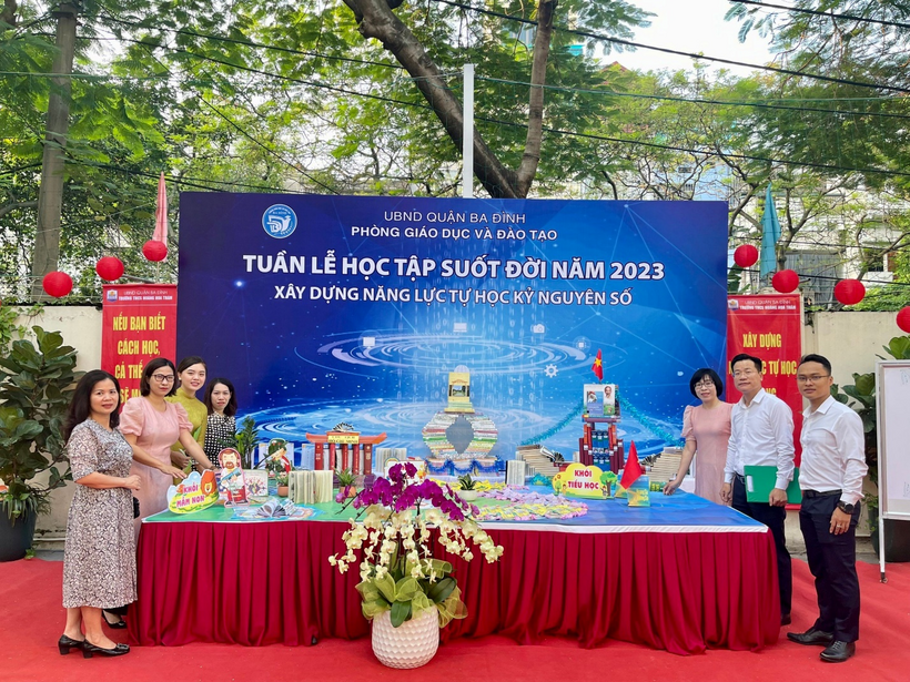 A group of people standing in front of a tableDescription automatically generated