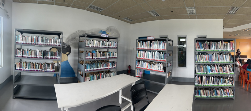 A room with a book shelfDescription automatically generated