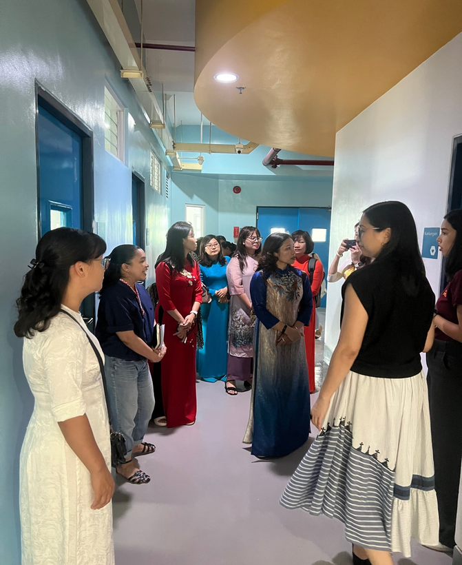 A group of women standing in a hallwayDescription automatically generated