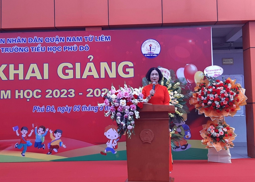 A person standing at a podium with a microphone and flowers

Description automatically generated