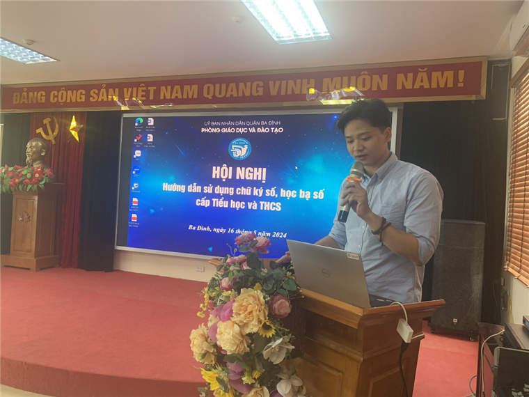 A person standing at a podium with a microphone

Description automatically generated
