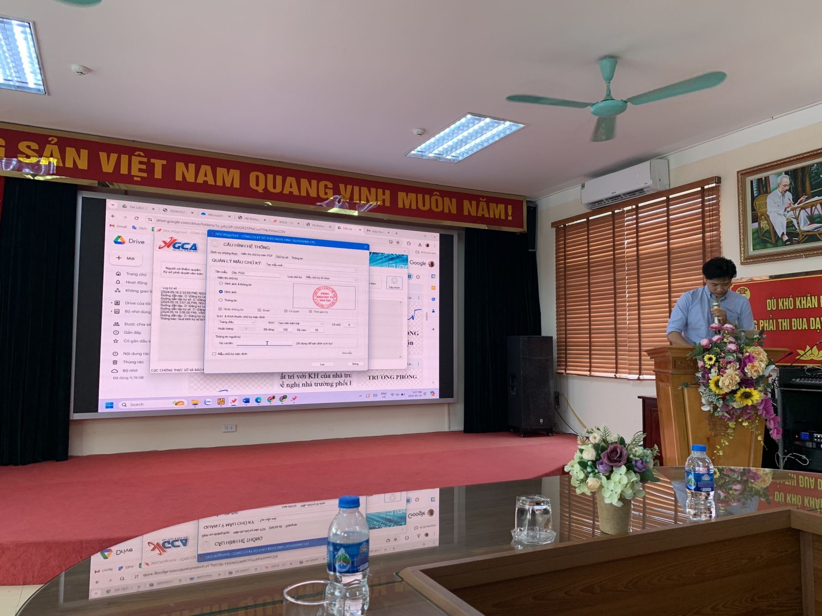 A person standing at a podium in front of a large screen

Description automatically generated