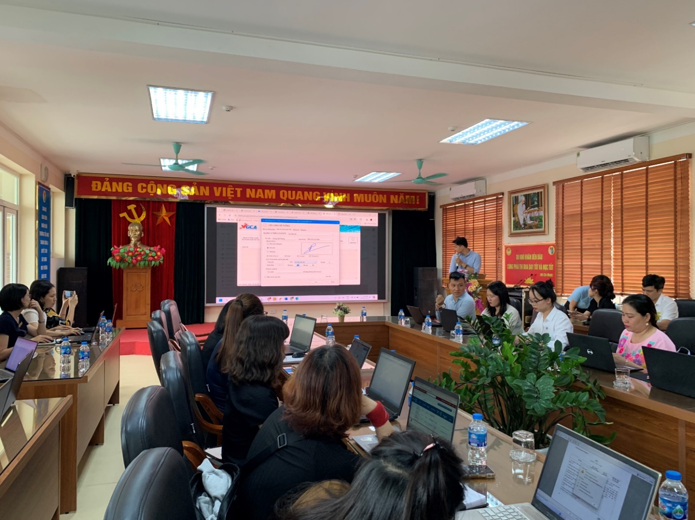 A group of people sitting in a room with laptops

Description automatically generated