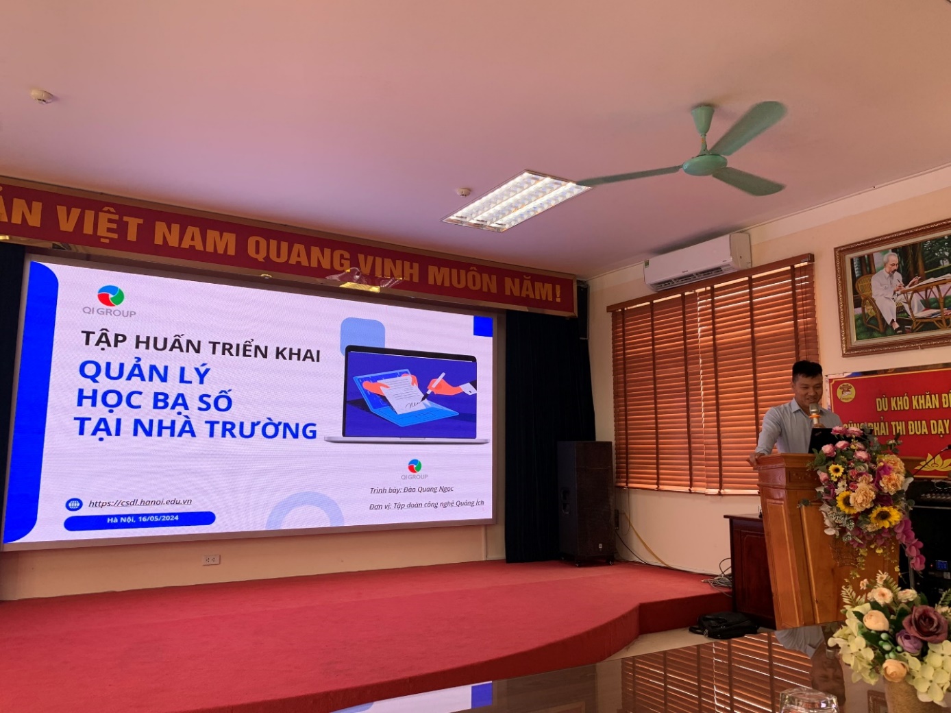 A person standing in front of a screen

Description automatically generated