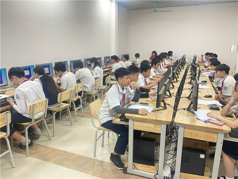 A group of people sitting at desks in a room with computers
AI-generated content may be incorrect.