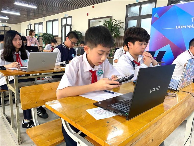 A group of kids sitting at a desk with laptops and a cellphone
AI-generated content may be incorrect.
